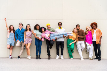 happy playful multiethnic group of young friends bonding outdoors - multiracial millennials students