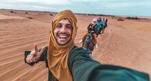 Happy Tourist Having Fun Enjoying Group Camel Ride Tour In The Desert - Travel, Life Style, Vacation Activities And Adventure Concept