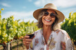 © Denis Yevtekhov - A joyful mature woman exploring a charming vineyard, savoring the taste of fine wines and the beauty of the landscape Generative AI