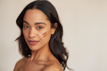 Wall Mural - beautiful mixed race woman trying foundation shades on cheek