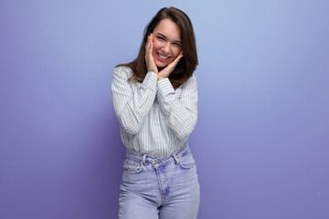 Canvas Print - european young brunette female adult in a striped shirt and jeans with hair below her shoulders in a studio background