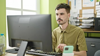 Wall Mural - Young hispanic man business worker using computer and smartphone working at office