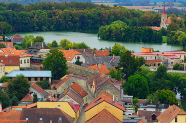 Canvas Print - Picturesque aerial landscape view of red tile roofs of medieval buildings and river with dense forest in the background. Typical small town in the Czech Republic. Travel and tourism concept