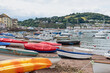 Small fishing boats and leisure craft moored and beached in Teignmouth harbour UK, with the village of Shaldon visible in the background on the opposite bank of the river Teign