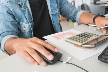 Front view hand man with jean jacket holding mouse with calculator on paper. working office concept. work or working concept. salaryman.