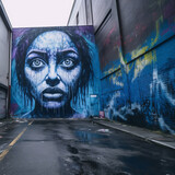 Fototapeta Nowy Jork - a womans face is painted on a wall in an alley