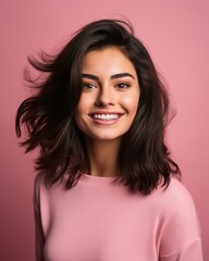 Wall Mural - portrait of a beautiful young woman with long black hair on pink background