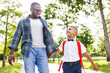 © JenkoAtaman - Schoolboy looking at father with smile while going with dad to first grade in school on sunny autumn day.