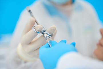 Wall Mural - Surgeon takes a syringe with anesthetic from hands of assistant