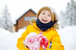 © Maria Sbytova - Happy preteen boy having fun playing with fresh snow during vacation in european Alps. Child dressed in warm clothes, hat, hand gloves and scarf.
