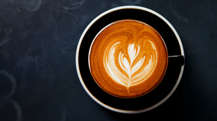 A cup of cappuccino coffee with soft foam on a wooden table. The coffee moment concept is everywhere.