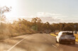 © Austockphoto - bokeh golden light over cars driving on highway with 100 speed limit sign