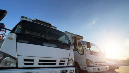 Wall Mural - Medium refrigerated or reefer trucks are parked at the truck stop at sunset. Extreme wide angle view. 