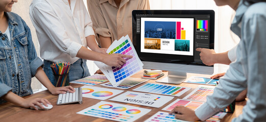 Leinwandbilder - Graphic designer brainstorming logo and graphic art at busy artistic workshop, laptop display workspace. Experimenting color palette and pattern for creative design. Panorama shot. Scrutinize