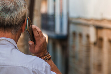 Wall Mural - mature man tourist with mobile phone through the rural streets