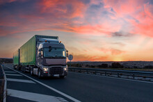 Set Of Duo-trailer Truck With Two Containers Driving On The Highway At Sunset With A Dramatic Sky.