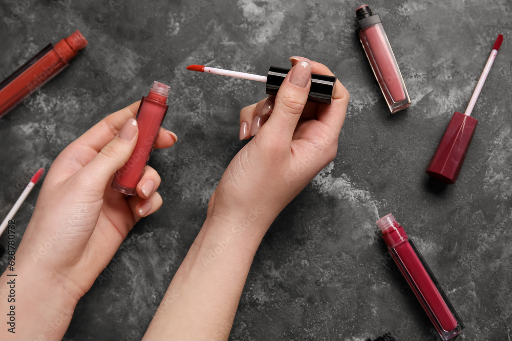 Woman with lipsticks on dark background