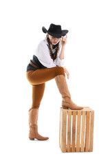 Wall Mural - Young cowgirl with wooden box on white background