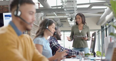 Wall Mural - diverse businesspeople discussing over a computer at desk at office