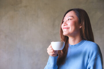 Poster - Portrait image of a beautiful young woman holding and drinking coffee