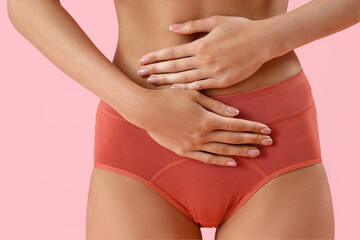 Wall Mural - Young woman in menstrual panties on pink background, closeup