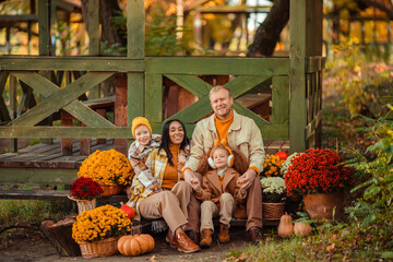 family traditions. multiethnic family i am in autumn in the park in a wooden gazebo next to pumpkins and flowers