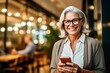 Senior businesswoman using smartphone in cafe
