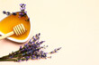 Bowl of sweet lavender honey, dipper and flowers on light background