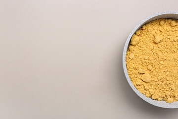 Bowl with ginger powder on grey background