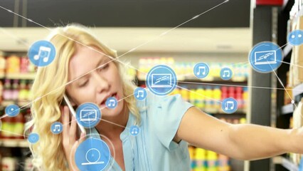 Poster - Animation of connected icons over caucasian woman talking on cellphone in grocery store