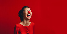 A Woman Laughing Hysterically Wearing A Red Nose For Red Nose Day On A Striking Bright Red Background.
