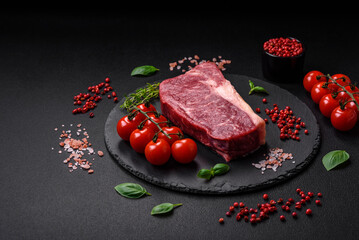 Fresh raw beef striploin steak with salt, spices and herbs