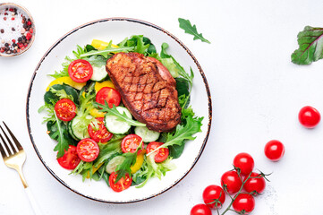 Wall Mural - Salad with grilled duck breast and cherry tomatoes, cucumber, paprika, lettuce and arugula on white table background, top view