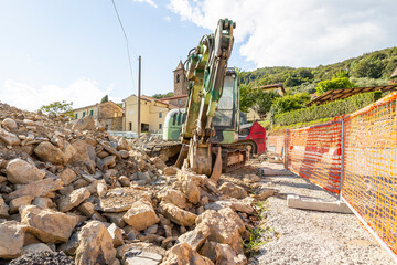 construction work in an ancient village - Hydraulic crusher excavator backoe machinery on a construction site