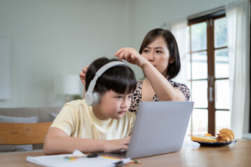 Parents helping children with homework at table at home.