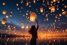 Young Woman Releasing A Sky Lantern Into The Night Sky