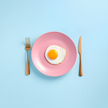Fried Sunny-side Up Egg In A Pink Plate On Turquoise Blue Background, Top View. Minimalistic Food Design. Protein Diet. 
