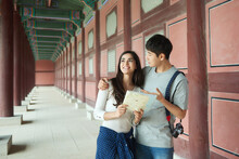 A College Student Couple Looking For Their Way Through A Map During A Trip To A Traditional Korean House