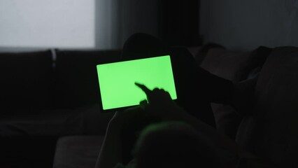 Sticker - Man at home lying on a couch with tablet pc with green screen