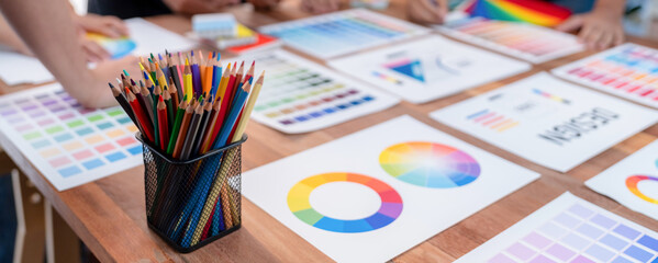 Leinwandbilder - Graphic designer brainstorm logo and graphic art at busy creative studio workshop. Experiment and brainstorm color palette and pattern at workspace table for creative design. Panorama shot. Scrutinize