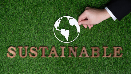 Environmentally sustainable and eco awareness campaign with text message, hand arranged into word Sustainable on biophilic green background. Eco-friendly energy sustainability encouragement. Gyre