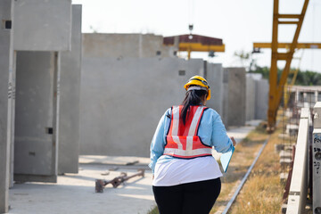 Sticker - Back view Portrait African american woman. Plus size female factory worker wearing safety hard hat helmet working at heavy Prefabricated concrete walls manufacturing factory