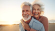 Leinwandbild Motiv lachendes älteres Paar am Meer umarmt sich