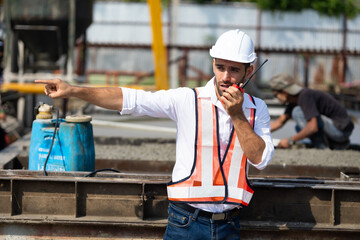 Wall Mural - radio transmitter. Hispanic latin architect construction Engineering man in hardhat talking on walkie talkie at factory facilities. Heavy Industry Manufacturing Factory. Prefabricated concrete walls