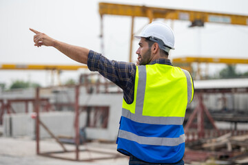 Wall Mural - radio transmitter. Hispanic latin architect construction Engineering man in hardhat talking on walkie talkie at factory facilities. Heavy Industry Manufacturing Factory. Prefabricated concrete walls