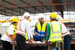© NVB Stocker - Success teamwork. Ethnic diversity worker people. Group of professional Construction engineering people wearing hardhat safety helmet meeting at Prefabricated concrete walls Industry Factory