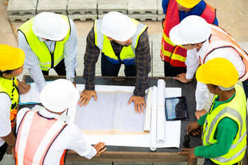 Wall Mural - Top view. Success teamwork. Ethnic diversity worker people. Group of professional Construction engineering people wearing hardhat safety helmet meeting at Prefabricated concrete walls Factory