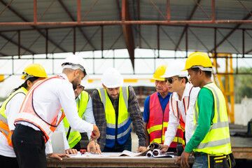 Wall Mural - Success teamwork. Ethnic diversity worker people. Group of professional Construction engineering people wearing hardhat safety helmet meeting at Prefabricated concrete walls Industry Factory