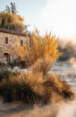 Poster - view of the Val d'Orcia region in Tuscany, Italy, featuring a house surrounded by the blue water