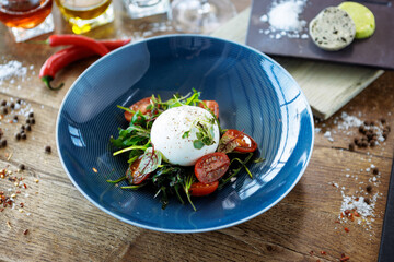 Wall Mural - Burrata with paprika-truffle jam and cherry-cluster tomato salad. Delicious healthy Italian traditional food closeup served for lunch in modern gourmet cuisine restaurant